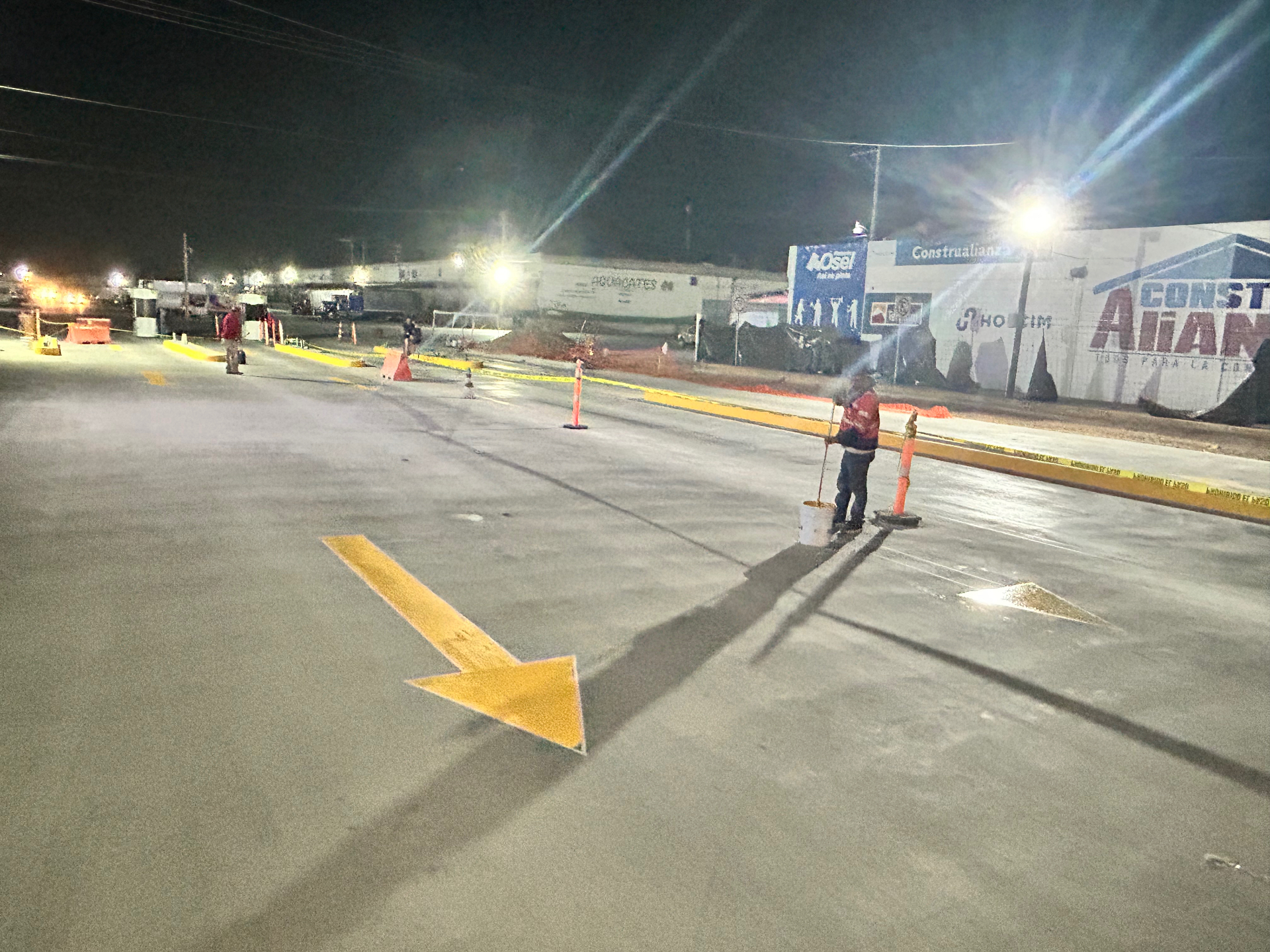 Aplicación nocturna de pintura de señalamiento en piso de concreto