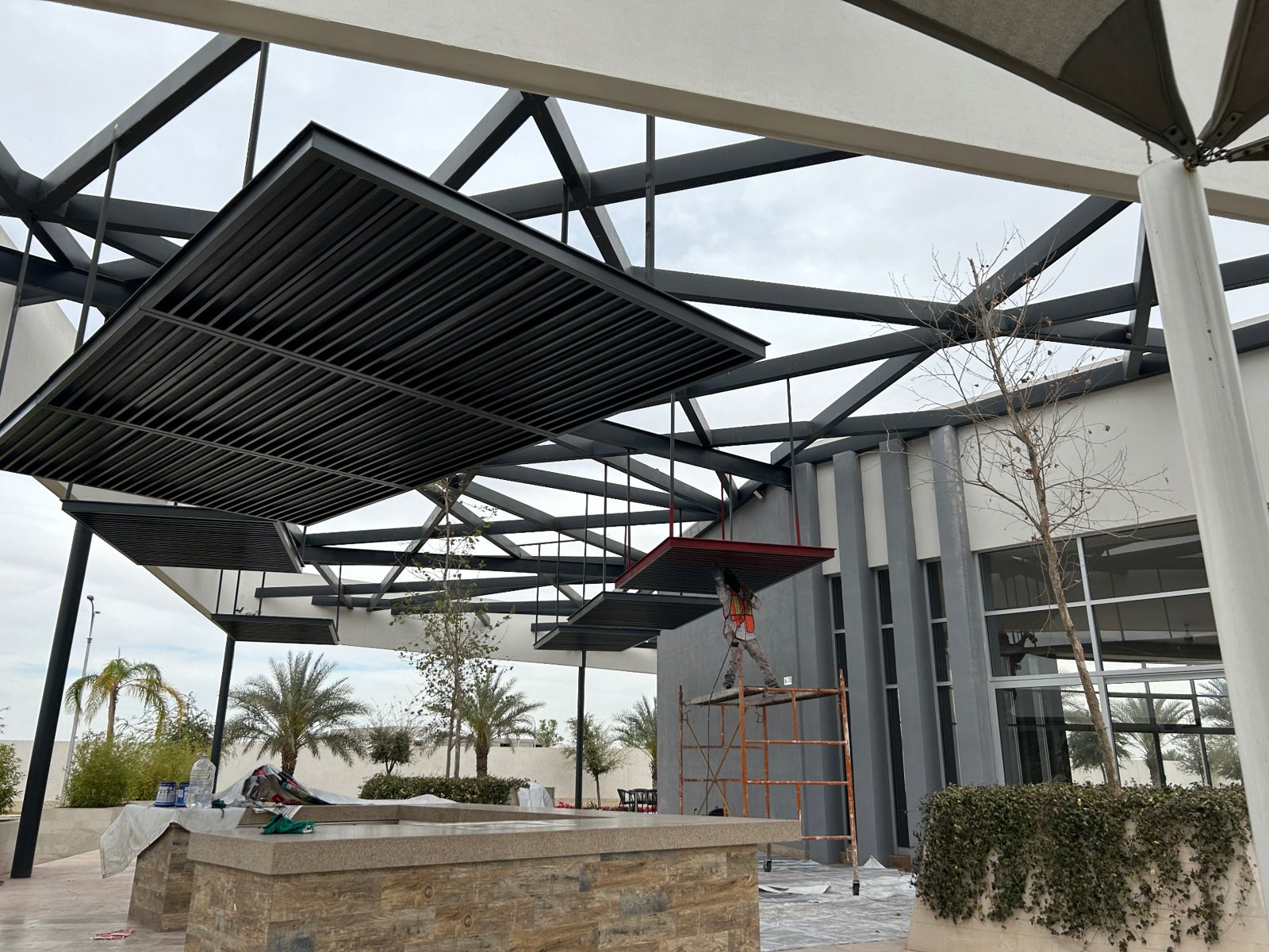 Aplicación de pintura sobre pérgola y estructura metálica en exterior.